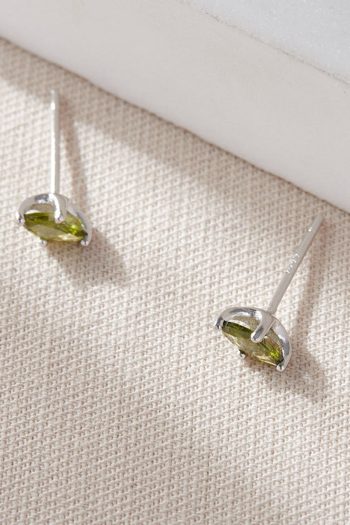 close up image of the silver olive green stud earrings, showing the oval shape of the studs