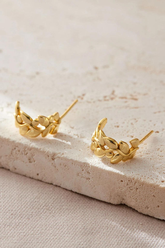 close up image of the gold plated sterling silver olive leaf half hoop earrings