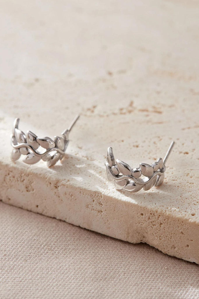 close up image of the sterling silver olive leaf half hoop earrings