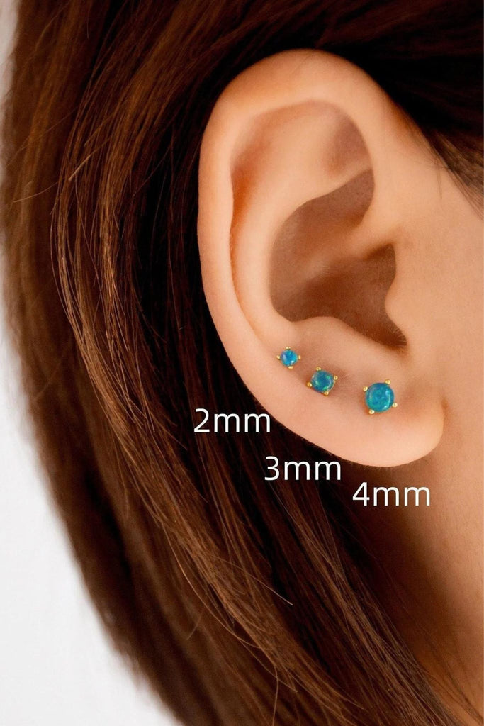 model wearing all three sizes of the teal opal stud earrings, showing that they can be worn as stacking earrings