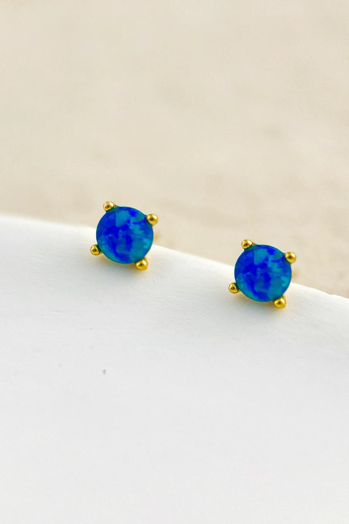close up of the blue opal earrings, showing a deep blue stone mounted in gold plated sterling silver
