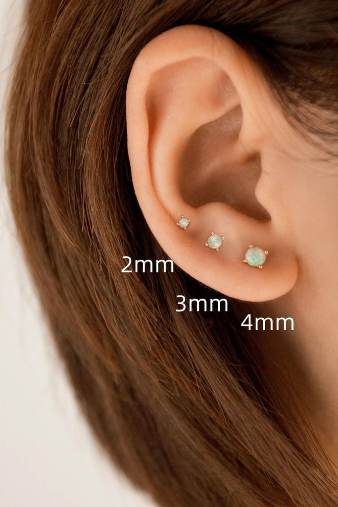 model wearing all three sizes of the white opal earrings, showing the size range from 2mm, 3mm and 4mm