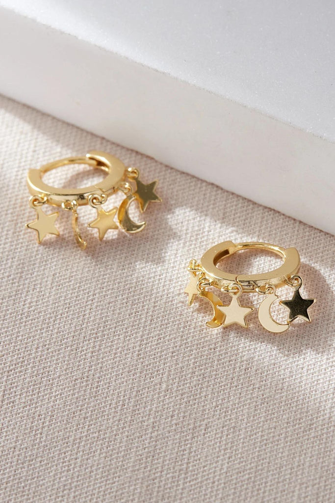 close up of the gold plated silver star and moon charm hoop earrings