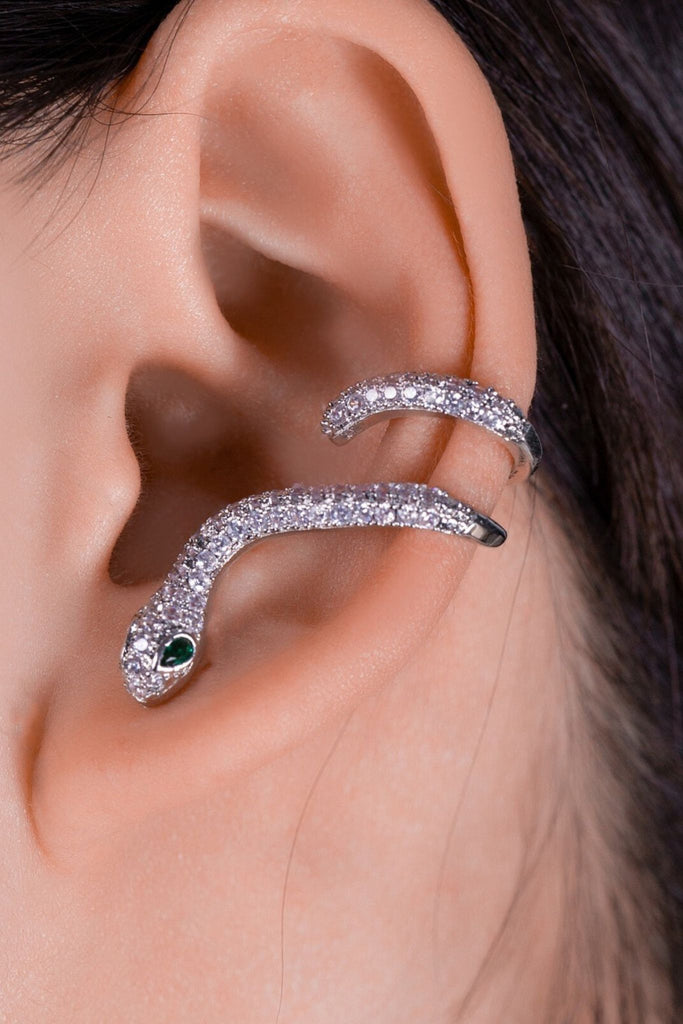 model wearing the silver coloured sparkly snake earring, the earring is secured in the earlobe and winds around the ear cuff
