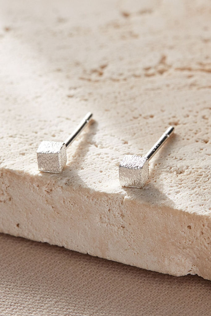 close up of the silver coloured square studs