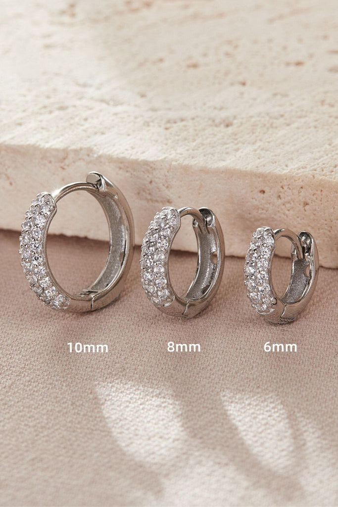 close up of the silver huggie hoops, showing the size differences between each option