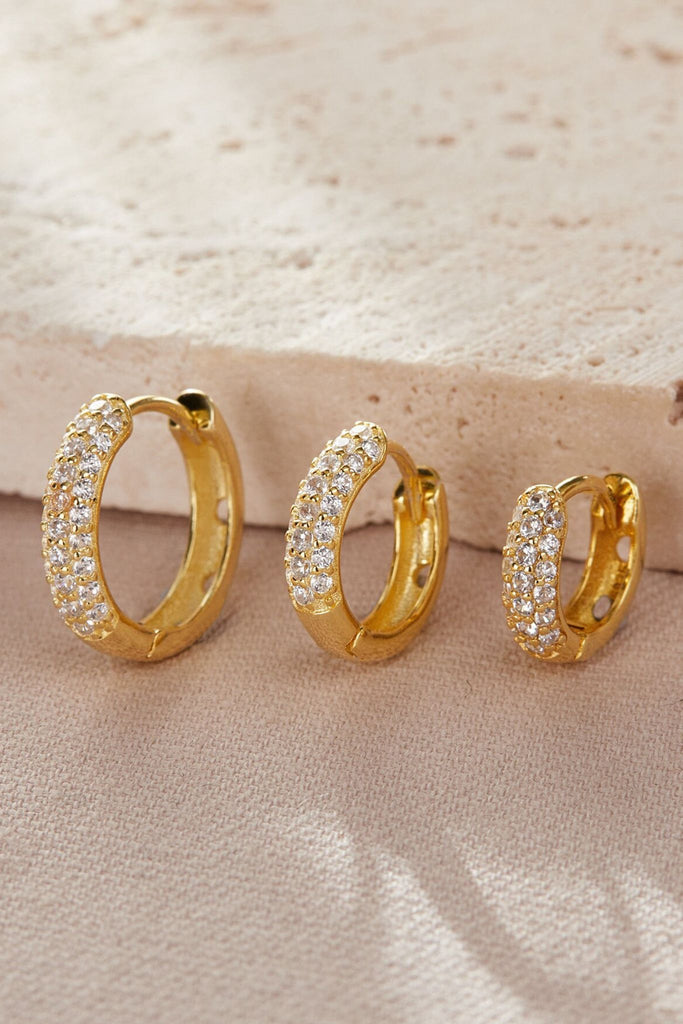 close up of the gold plated silver huggie hoops, showing the size differences between each option