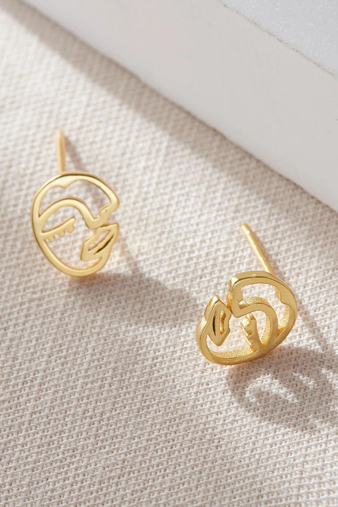 close up of the gold plated silver face stud earrings 