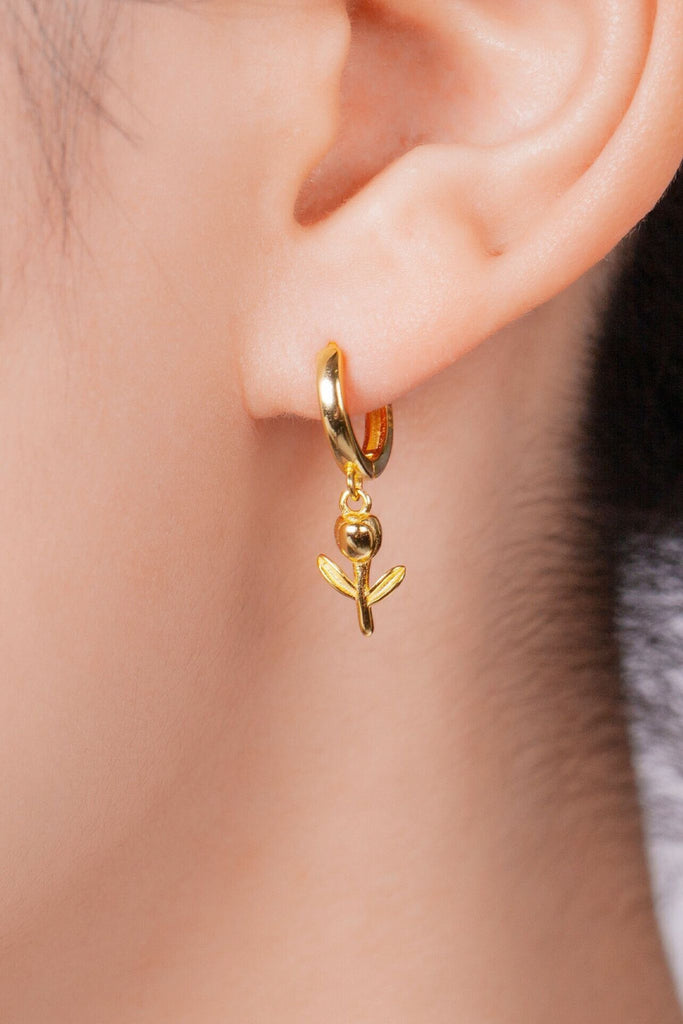 model wearing a gold tulip dangle hoop earring