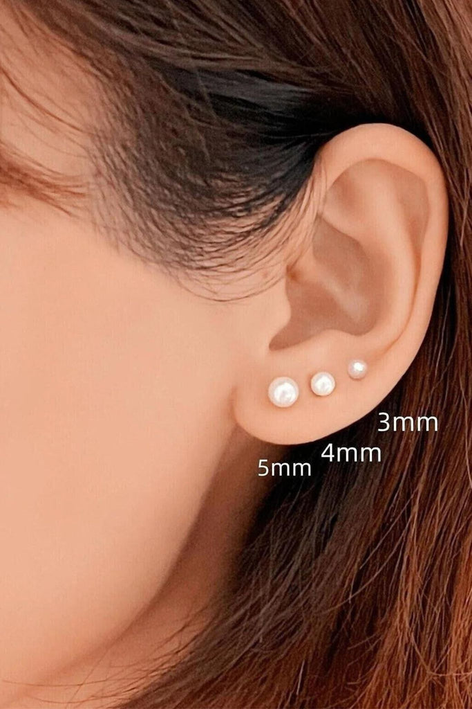 model wearing three sizes of white faux pearl stud earrings, 3mm, 4mm, 5mm