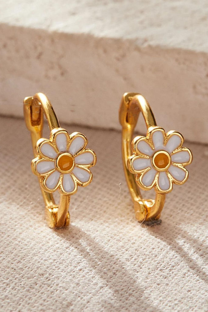 close up of the gold plated silver daisy hoop earrings, showing the white daisy flower with a yellow middle