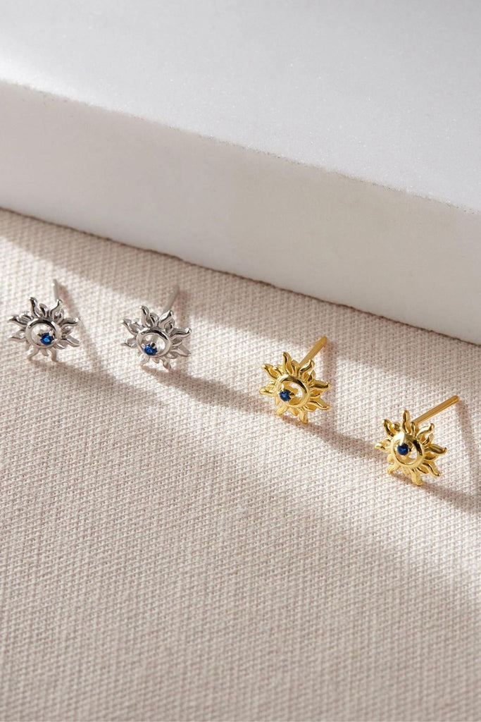 silver and gold coloured s925 sterling silver sun stud earrings, each earring features a small blue cz crystal in the centre of the earring