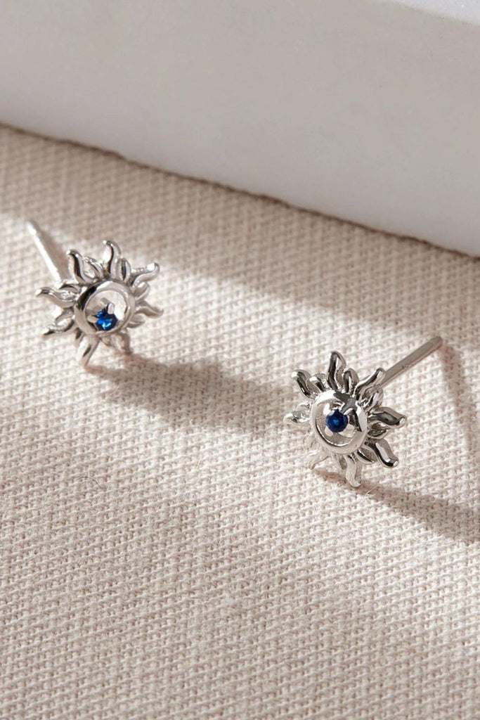 close up of the silver solar stud earrings, showing the blue cz crystal in detail