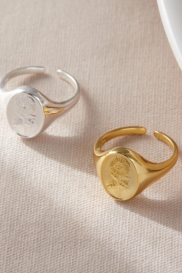 silver and gold plated sterling silver open signet rings, each featuring a sunflower design on the flat surface of the ring