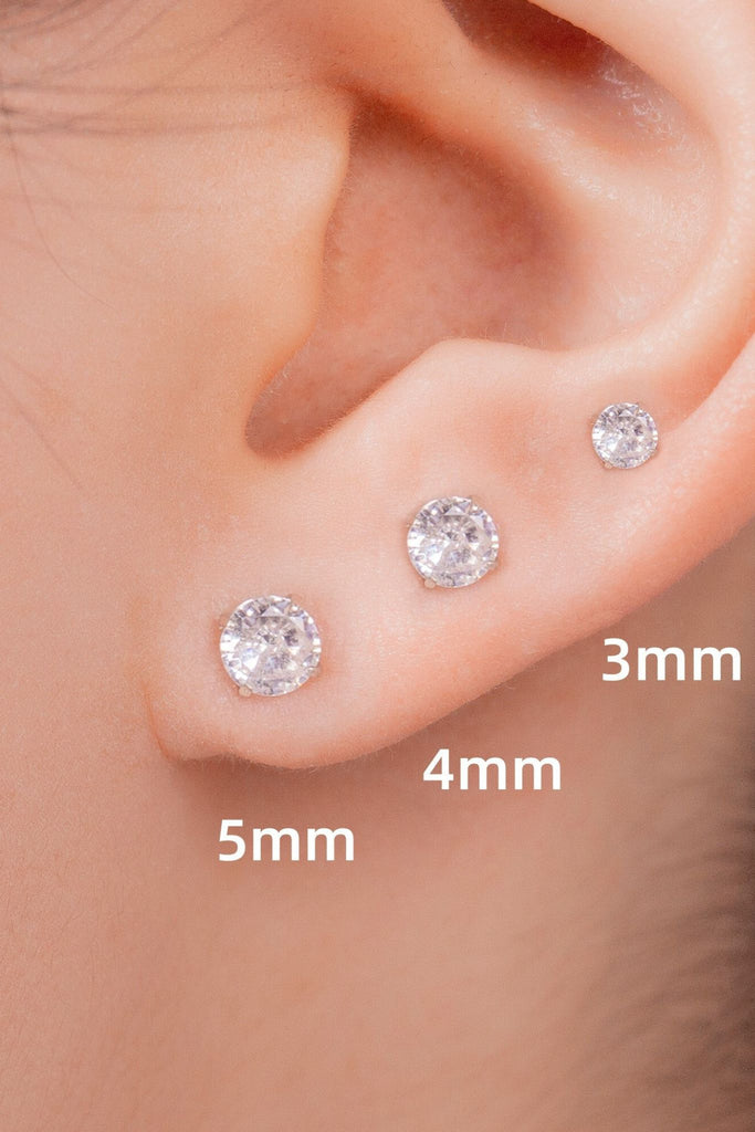 model wearing 3mm, 4mm and 5mm sparkly crystal studs on the earlobe, showing that these earrings can be stacked 