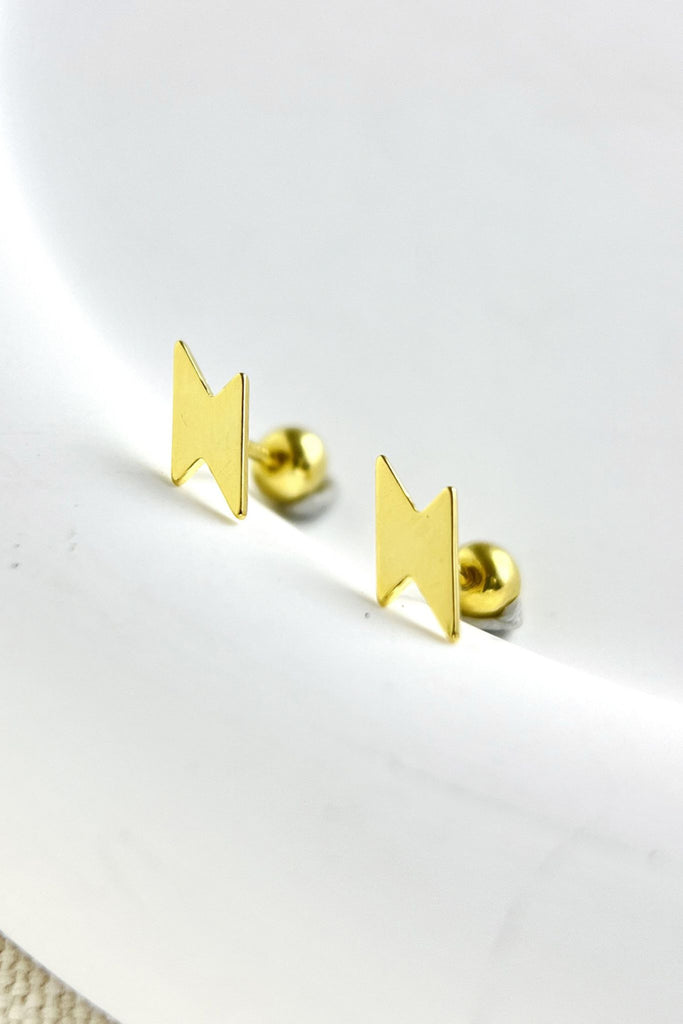 close up of the gold coloured sterling silver lightning bolt cartilage stud earrings, showing the ball back fastenings