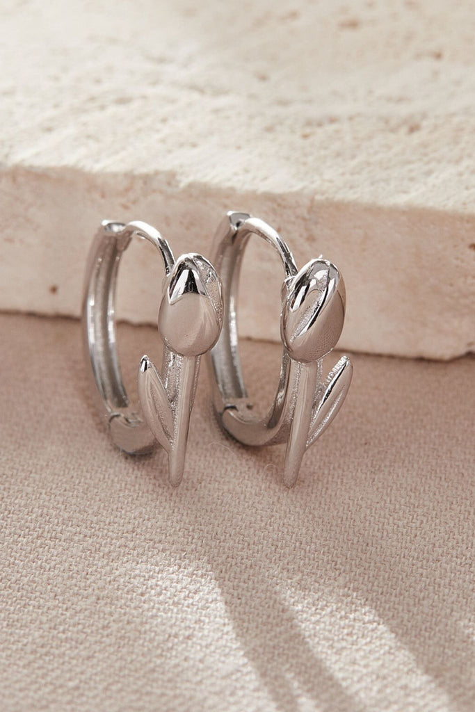 close up of the silver tulip hoop earrings, showing the flower detail on the front of the hoops 