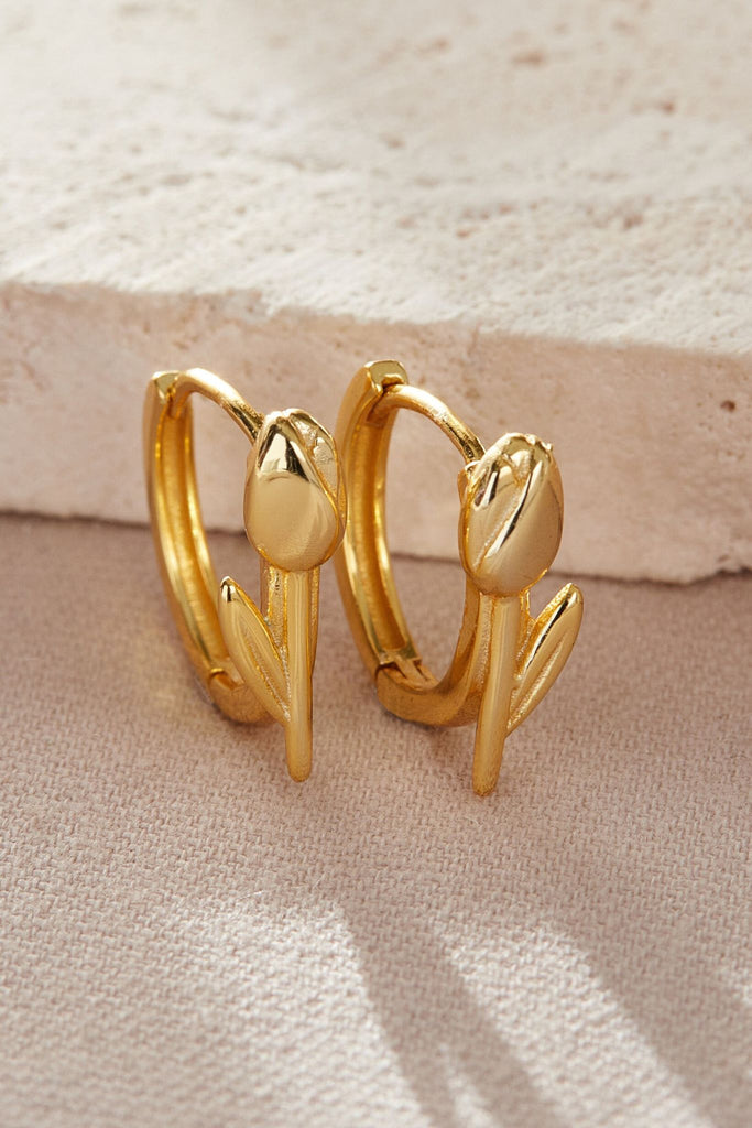 close up of the gold tulip hoop earrings, showing the flower detail on the front of the hoops 