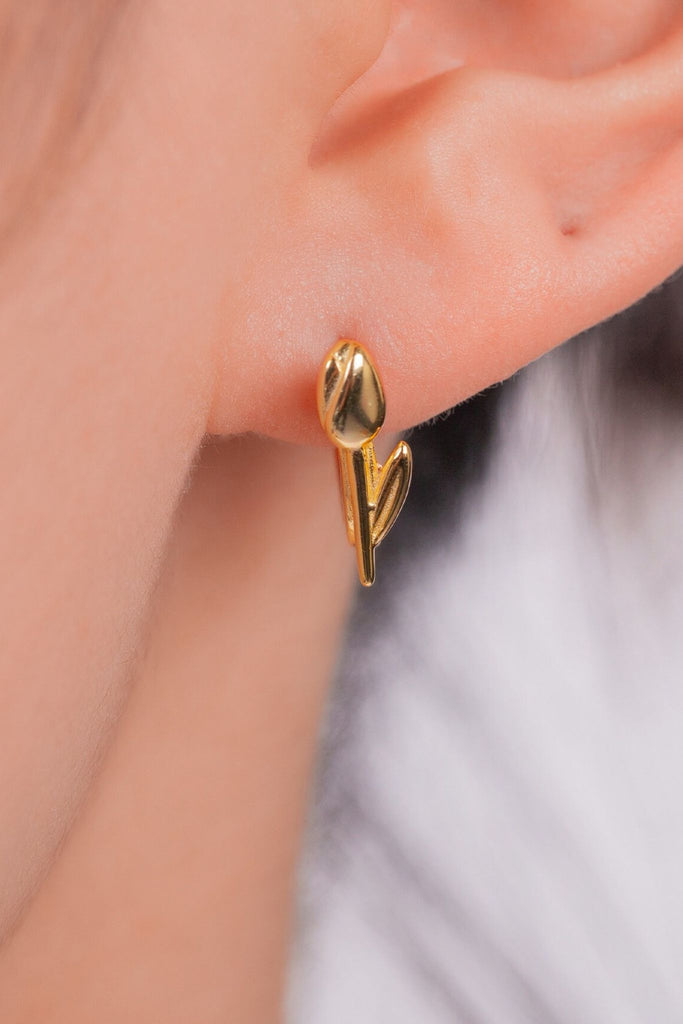 model wearing the gold plated silver tulip hoop earring in the earlobe showing how the tulip detail appears when being worn