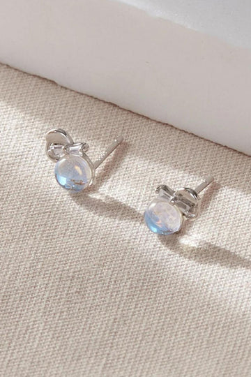 round moonstone style stud earrings set in S925 sterling silver, the moonstones are decorated with a dainty bow made from silver.