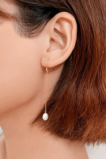 pearl drop dangle earrings, with hook back. these long pearl drops are attached to a gold plated dainty chain and hang below the jawline