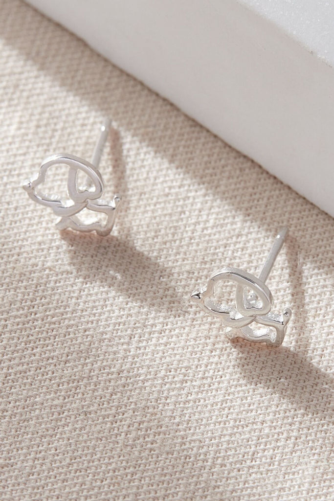close up of the outline  silver dog stud earrings, showing the cartoon like design