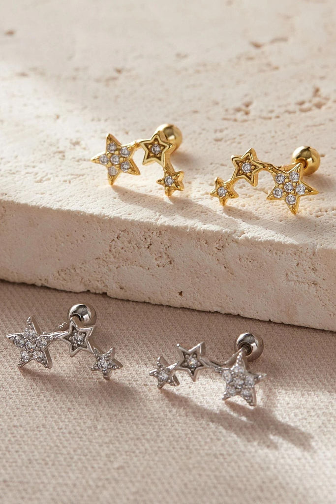 silver and gold plated sterling silver triple star stud cartilage stud earrings, each earring has three stars of large, medium, small size all encusted with dainty white cz crystals, the earrings have screw ball back fastenings