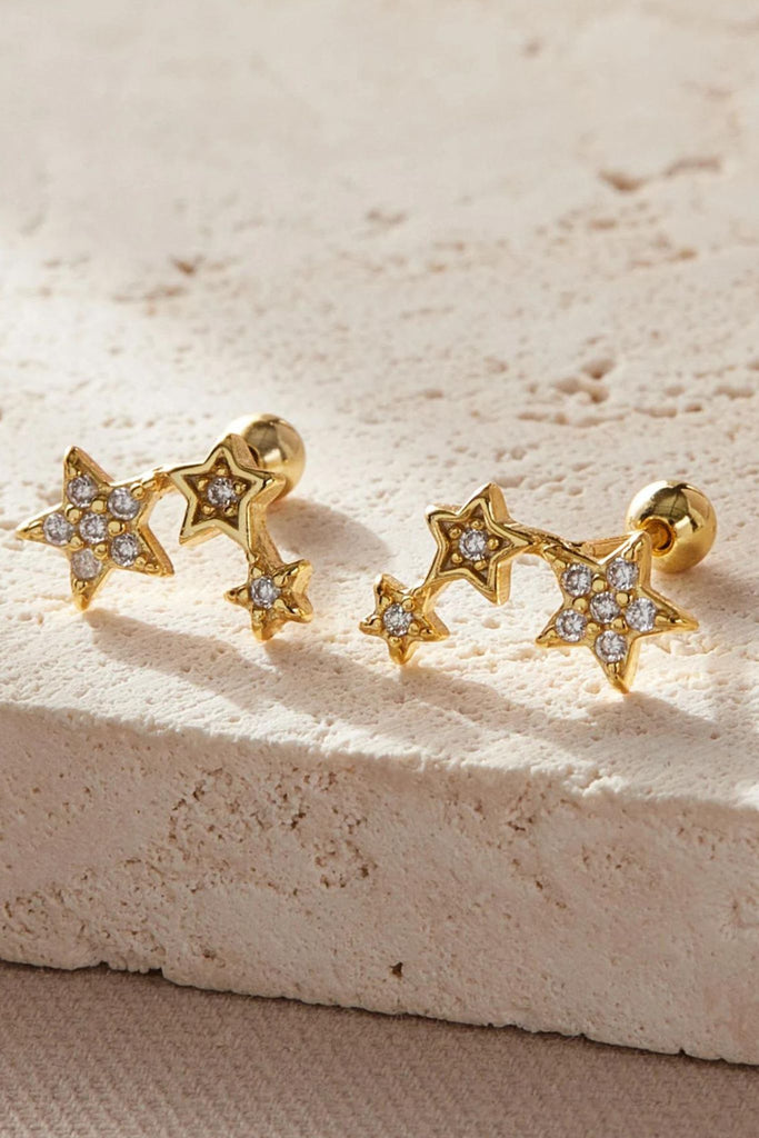 close up of the gold sparkly triple star carilage stud earrings, three stars made from gold plated silver adjoined and encrusted with sparkly cz crystals