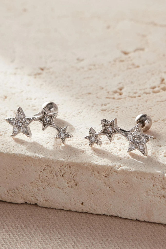 close up of the silver sparkly triple star carilage stud earrings, three stars made from silver adjoined and encrusted with sparkly cz crystals