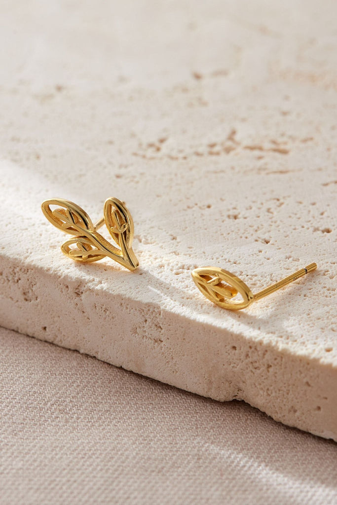 close up of the gold plated sterling silver asymmetrical olive leaf earrings