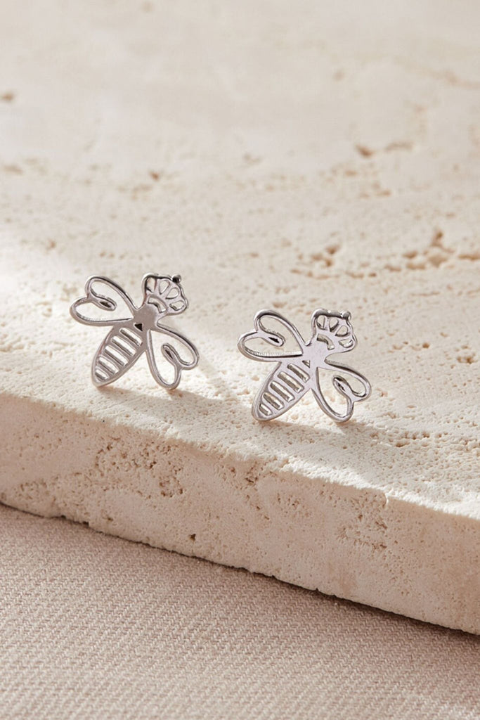 close up of the silver queen bee stud earrings, showing the detail of the crowns they are wearing