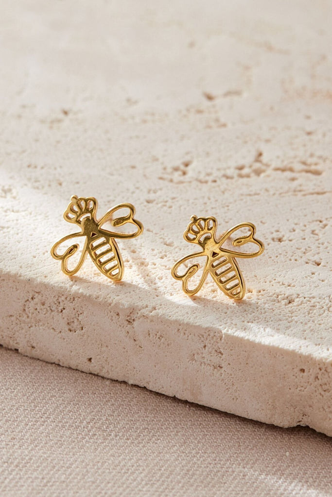close up of the gold plated silver queen bee stud earrings, showing the detail of the crowns they are wearing