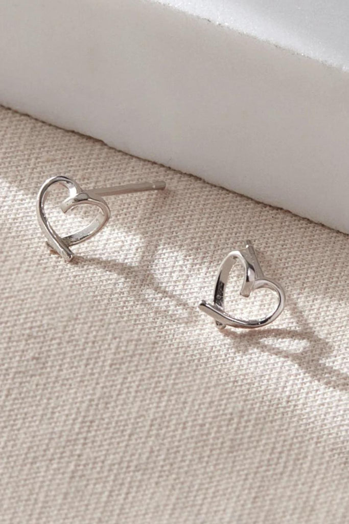 close up of the silver abstract love heart stud earrings, showing closely the swirl twist in the middle of the heart
