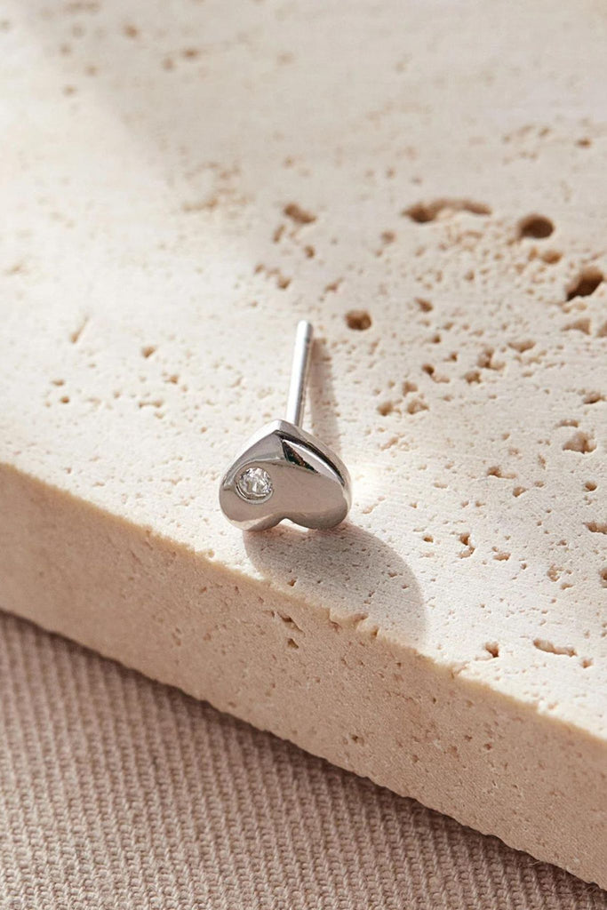 close up of the silver heart stud earring showing the dainty single cz crystal accent