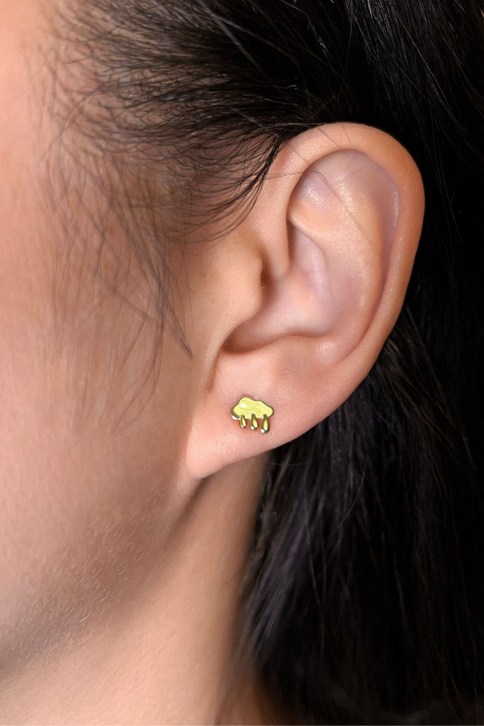 model wearing the gold rain cloud stud earring on the earlobe showing the dainty size of the earrings