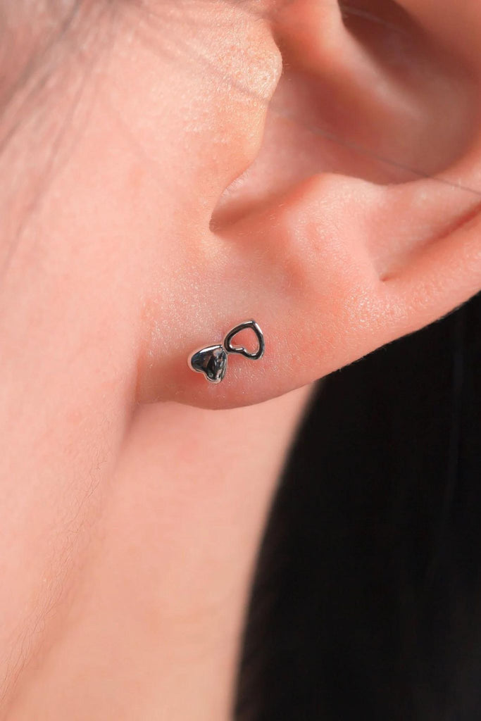 model wearing the silver double heart stud earring, showing the dainty size of the studs