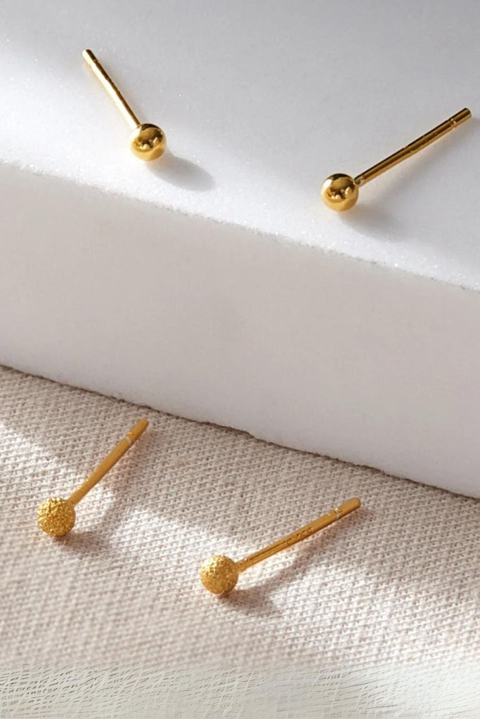 small gold coloured round ball stud earrings, one pair have a smooth finish, the other pair appear frosted