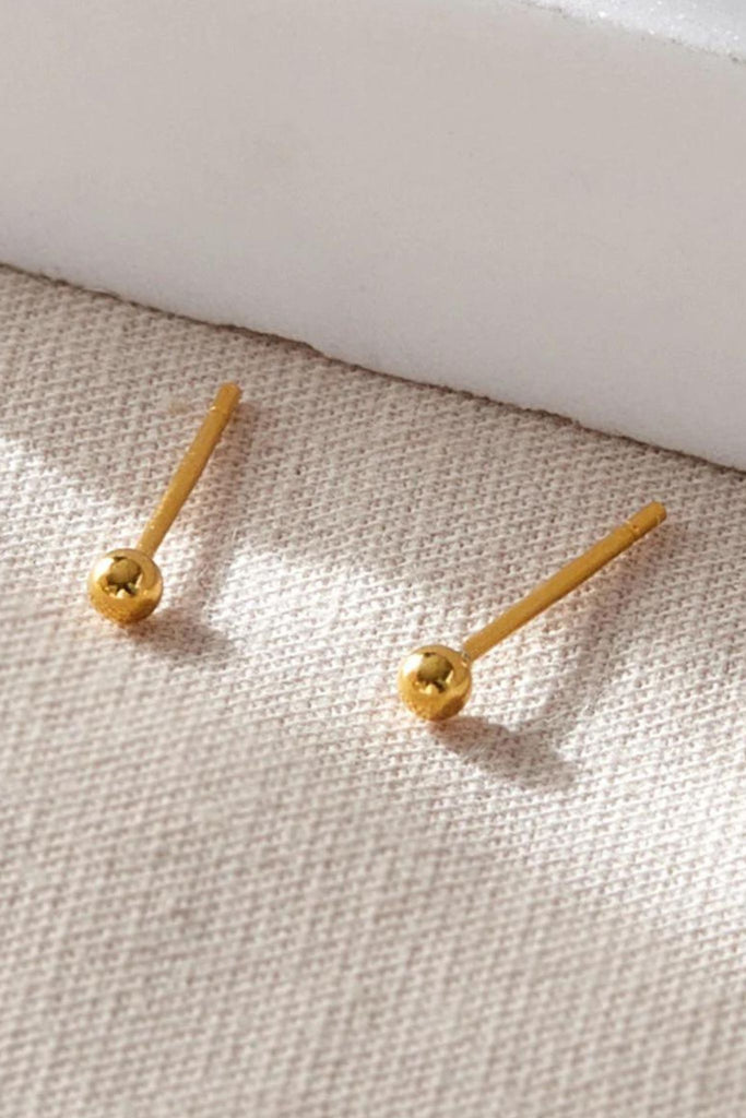 close up of the smooth gold ball stud earrings
