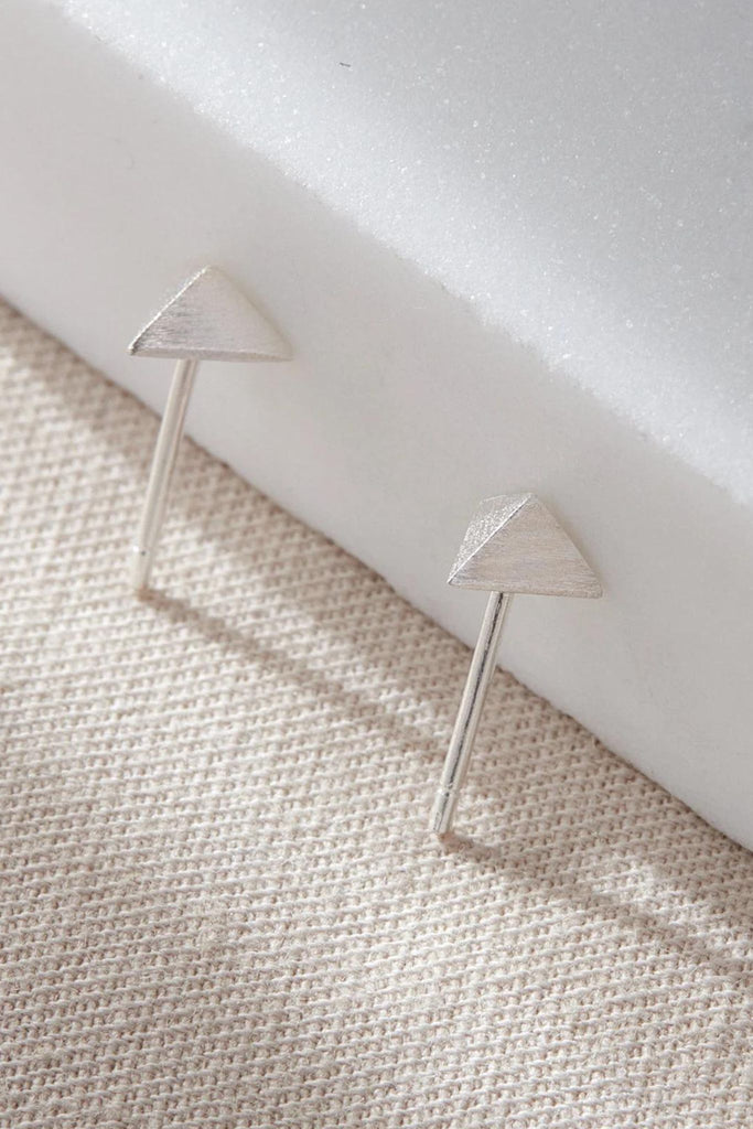 close up showing the three dimensional triangle stud earrings