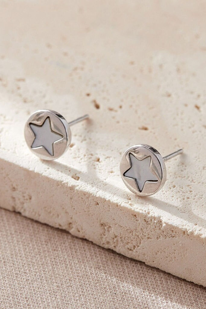 round silver stud earrings with a mother of pearl star in the middle