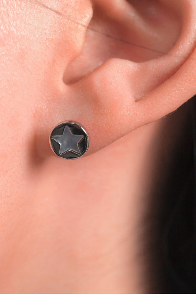 model wearing the sterling silver star stud earring on the earlobe, showing the size of the earrings