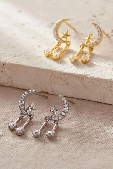 silver and gold coloured s925 earrings featuring a crescent moon and star stud with two dangly cz crystals which hang below the stud. the earrings are encrusted with white cz