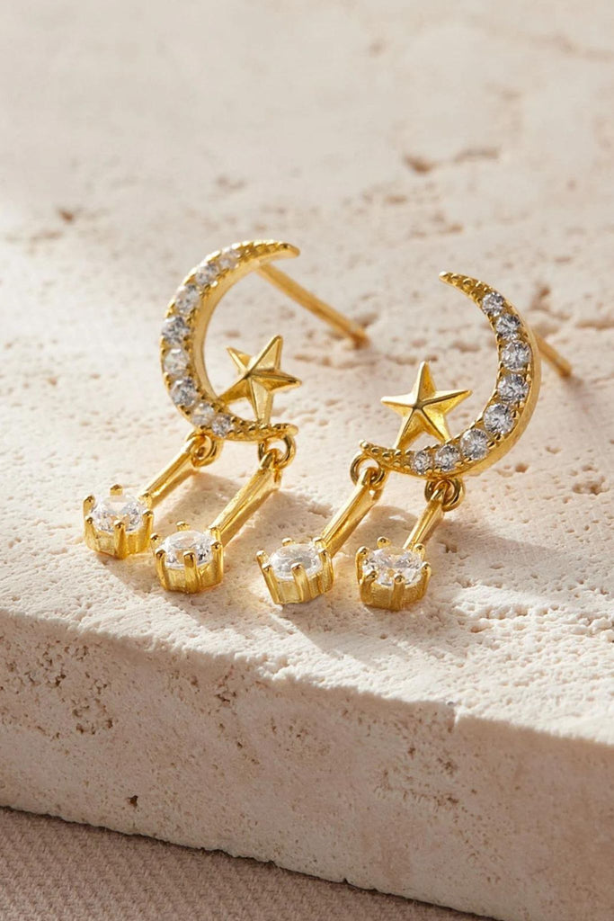 close up of the gold coloured star moon sparkly dangle stud earrings