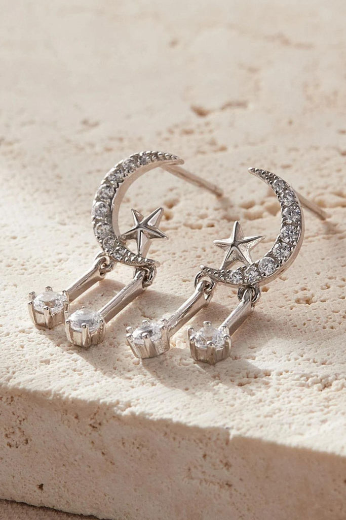 close up of the silver coloured star moon sparkly dangle stud earrings
