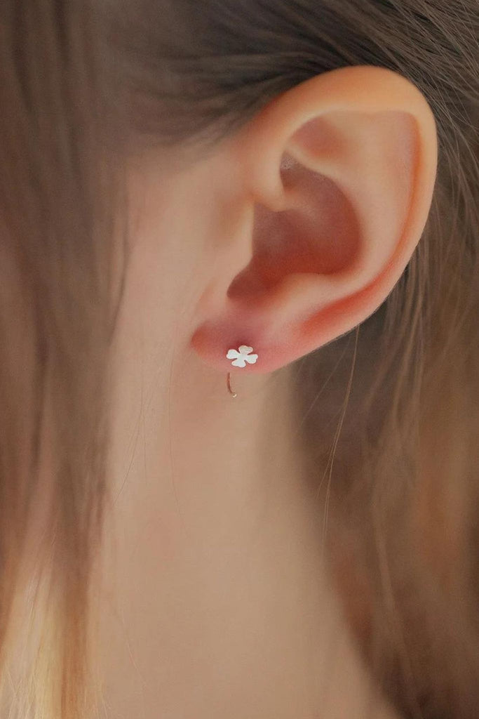 model wearing the four leaf clover earring through the earlobe showing how it looks when worn