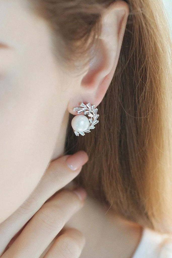 model wearing a silver pearl olive leaf statement stud earring on the earlobe