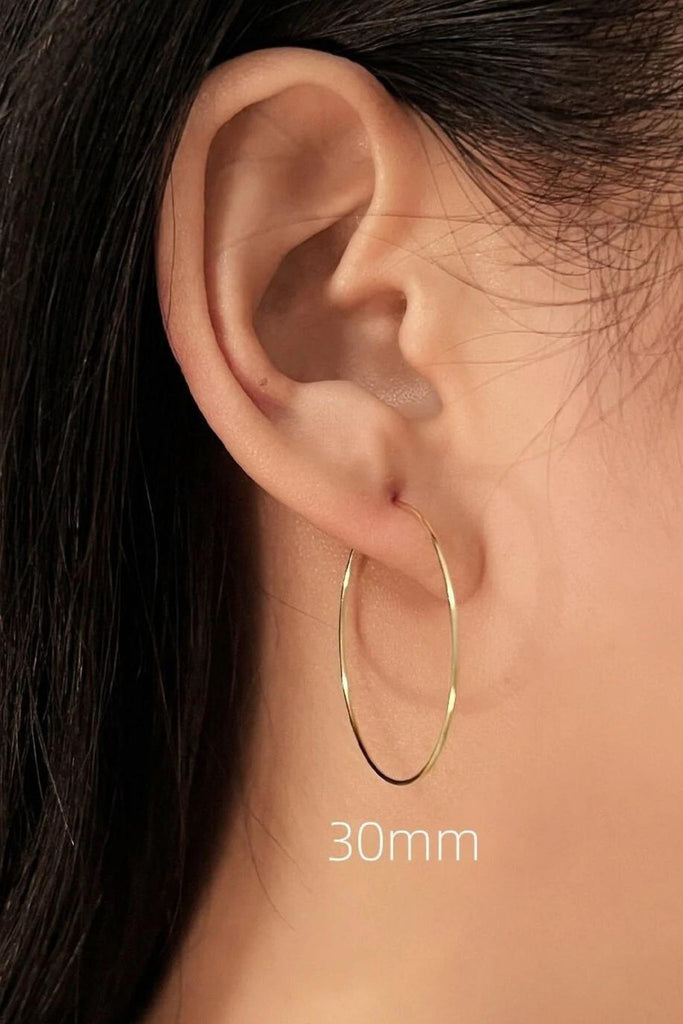 model wearing the 30mm gold hoop showing how it looks when worn