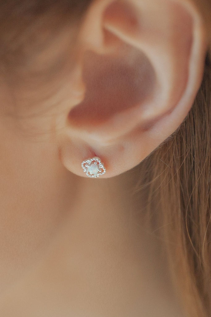 model wearing the silver opal floral stud earring on the earlobe showing the dainty size of the studs