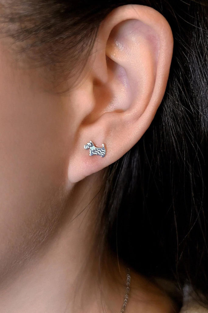 model wearing the silver scottie dog stud earring on the earlobe showing the dainty size of the earrings