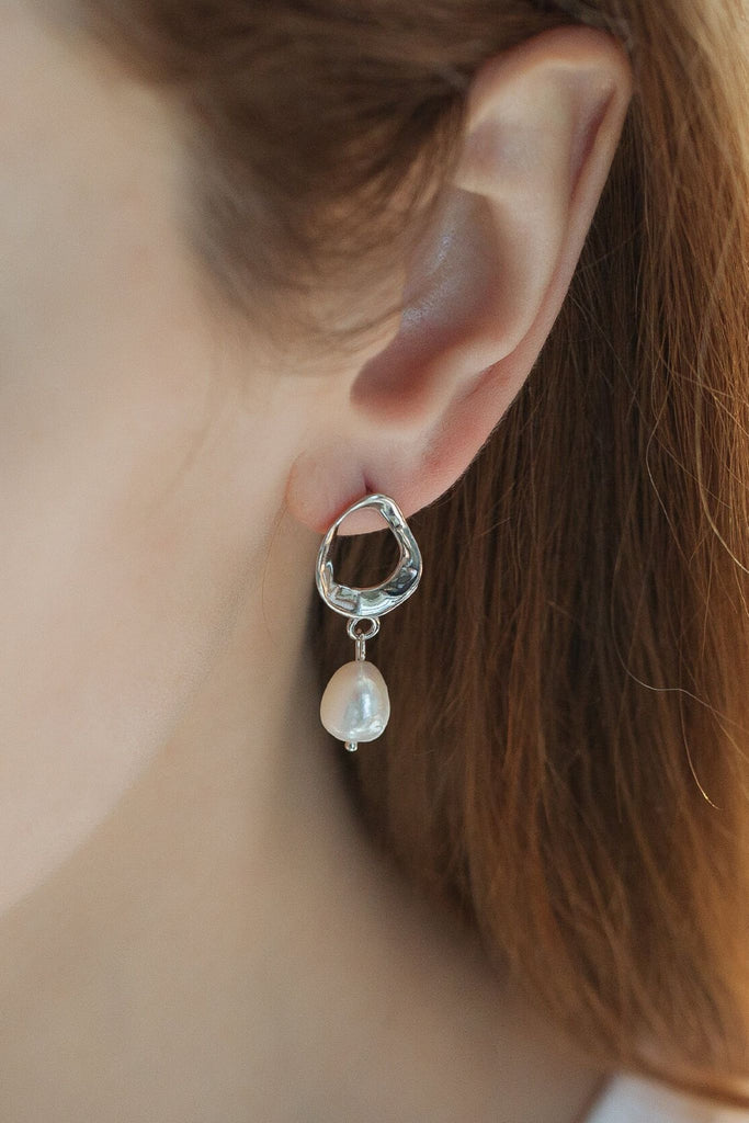 model wearing the silver pearl earrings, showing what it looks like when worn